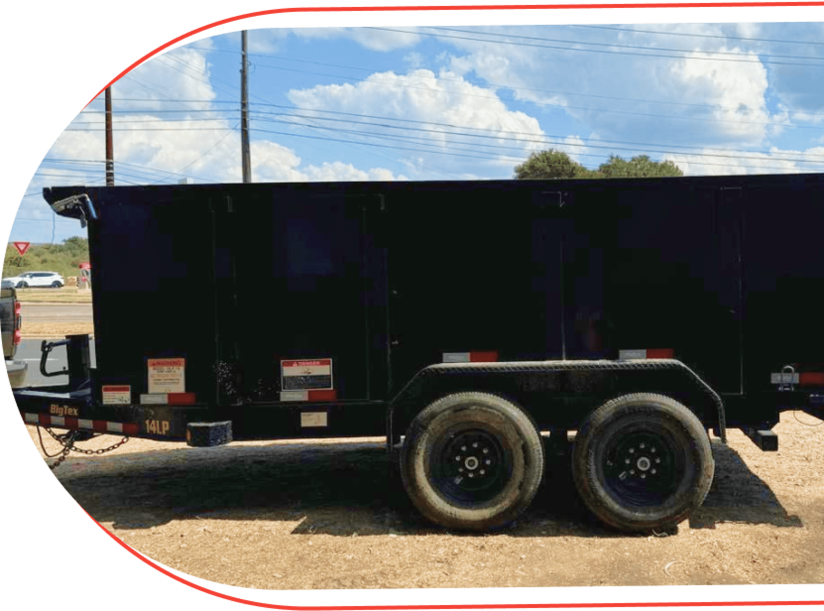 Black dump trailer on sunny day.